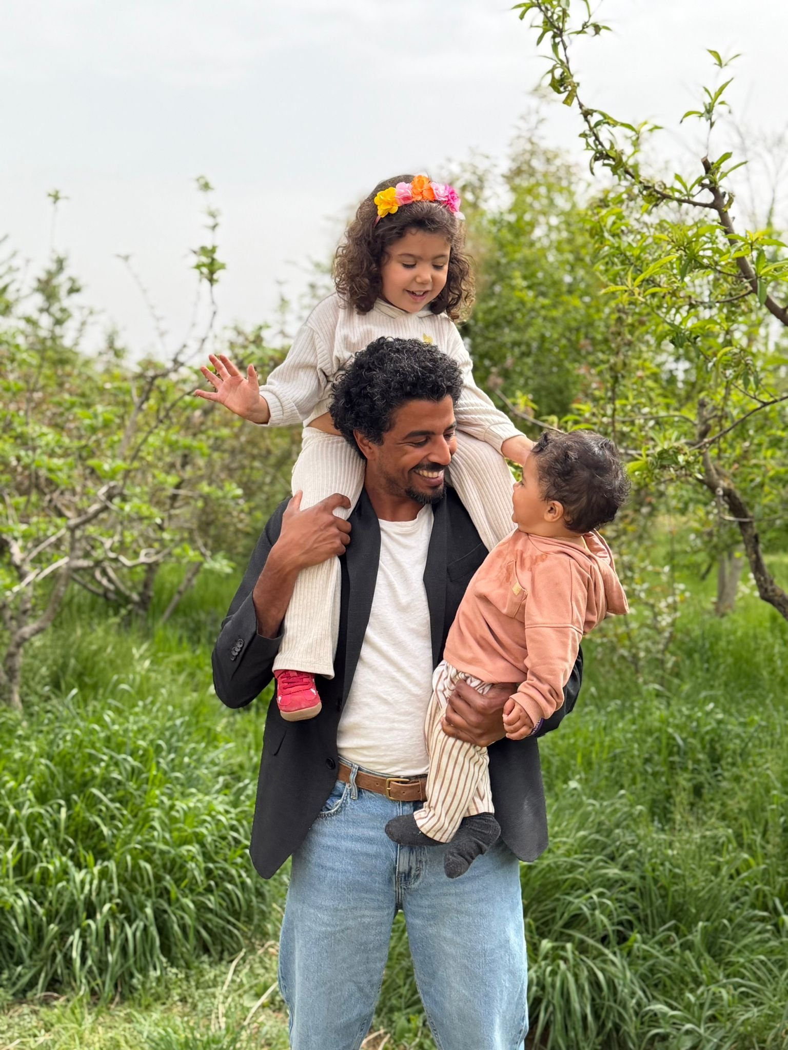 Endika Drame en el campo, con sus dos hijos en brazos y sobre los hombros